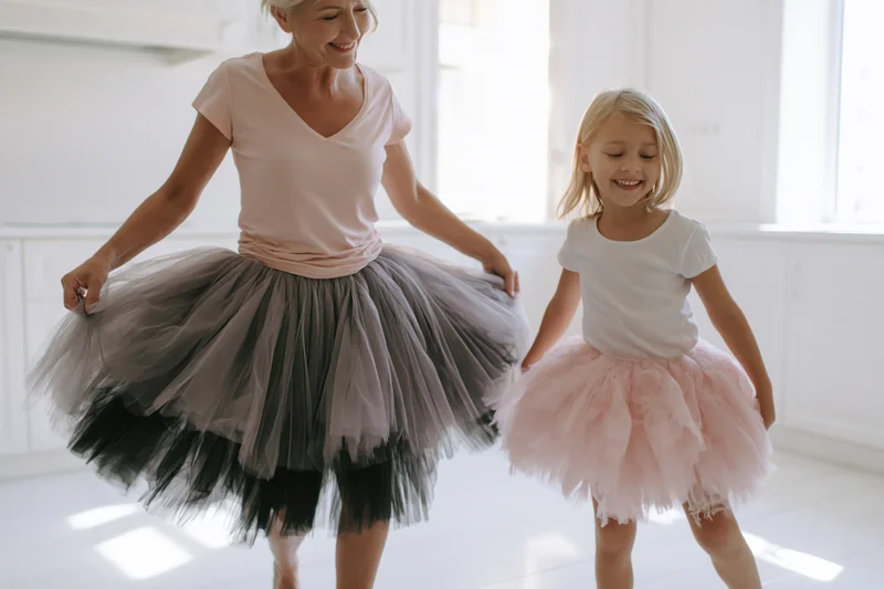 Mother and daughter dancing in tutus in a bright home interior