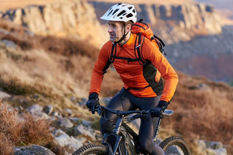 Man riding mountain bike on rocky trail in rugged outdoor landscape