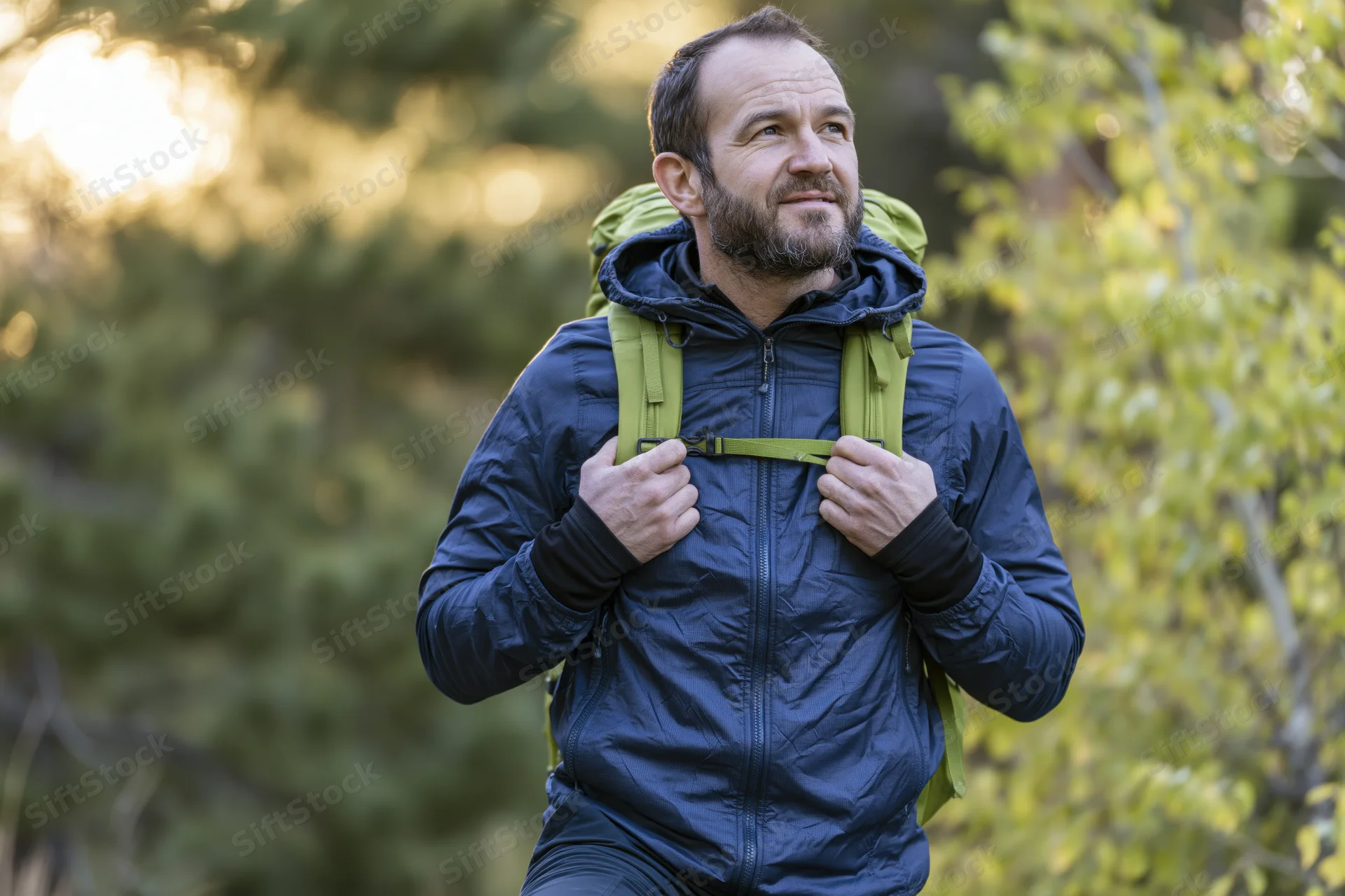 Man hiking with backpack in sunlit forest