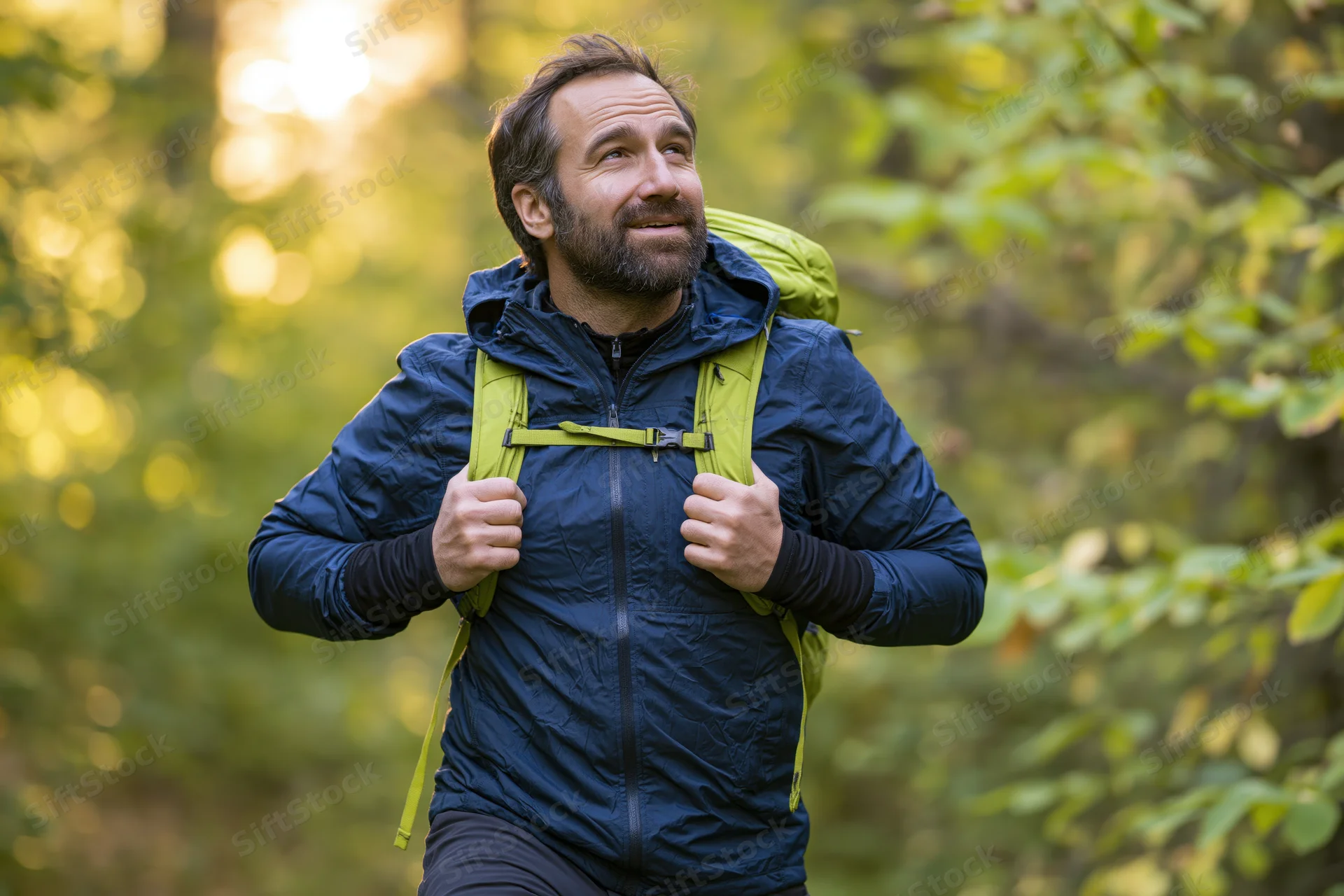 Man hiking with backpack in sunlit forest, smiling and adjusting straps