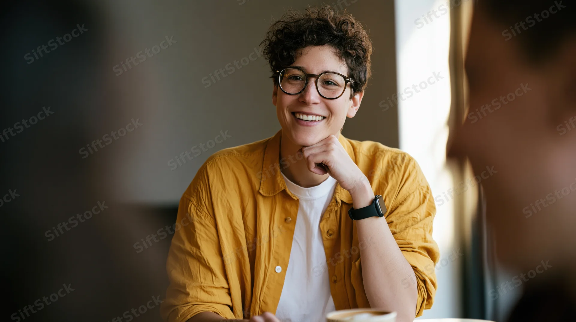 Woman smiling during a casual conversation in a cafe