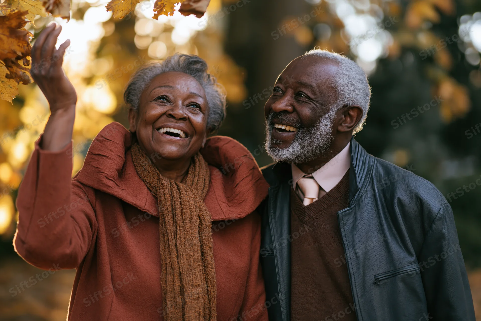 Elderly african american couple laughing together outdoors in autumn foliage