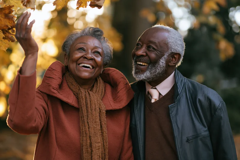 Elderly african american couple laughing together outdoors in autumn foliage