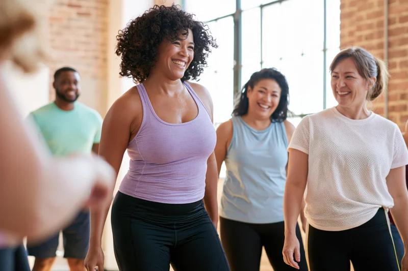 Woman smiling during dance class in sunlit studio with group of adults exercising