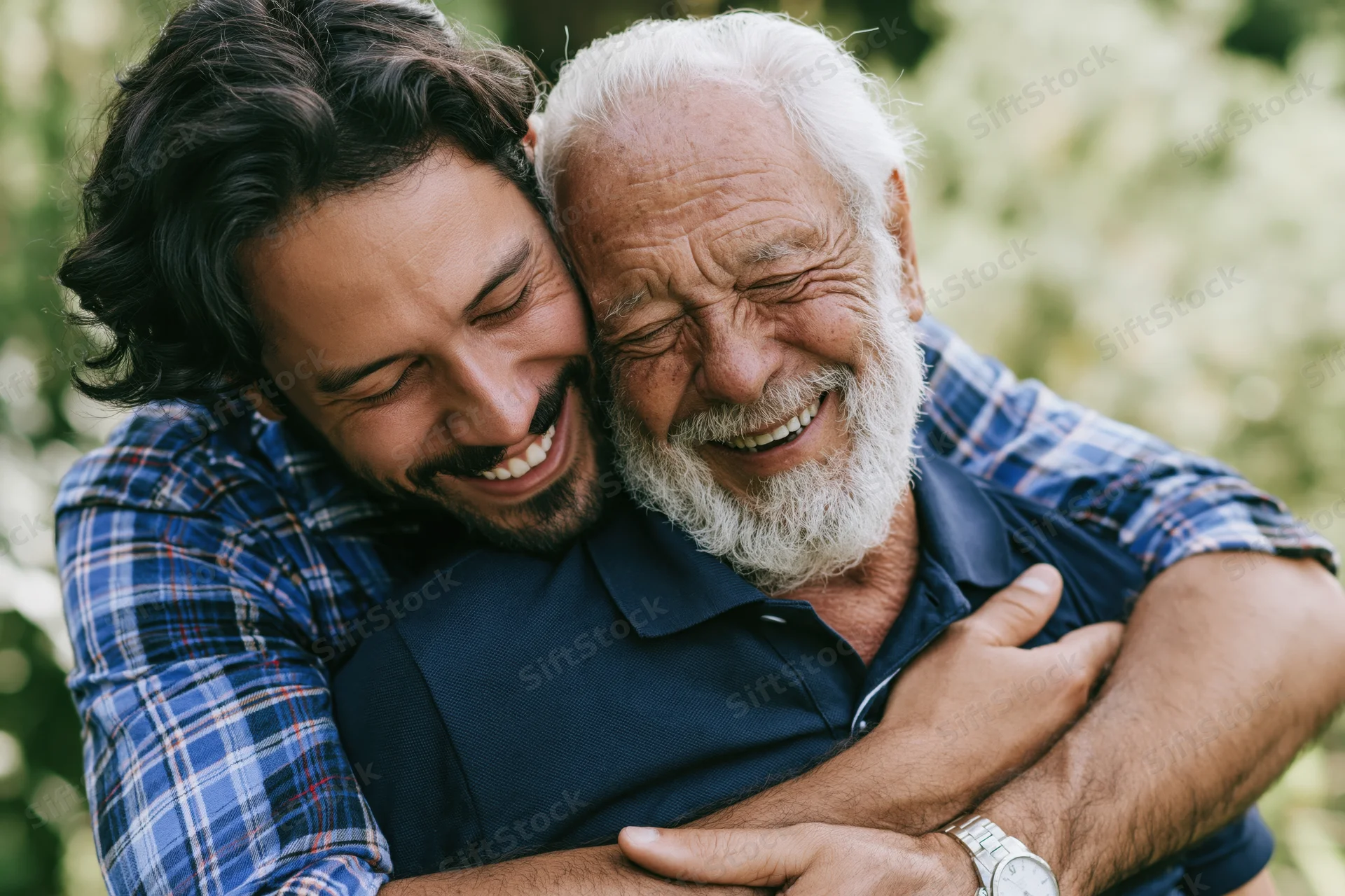 Young man hugging his elderly father outdoors, both smiling warmly