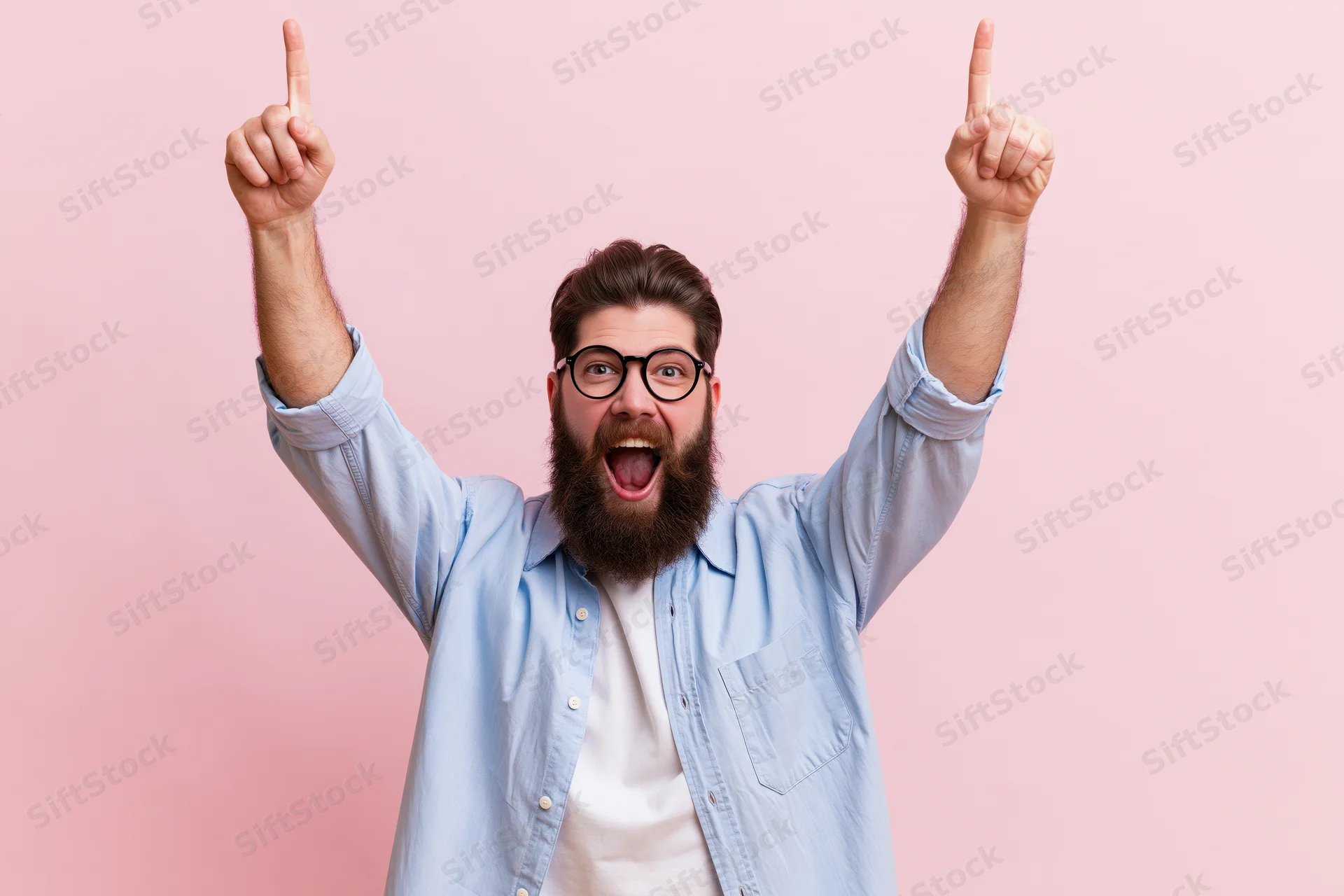 Bearded man celebrating with arms raised pointing upward against pink background