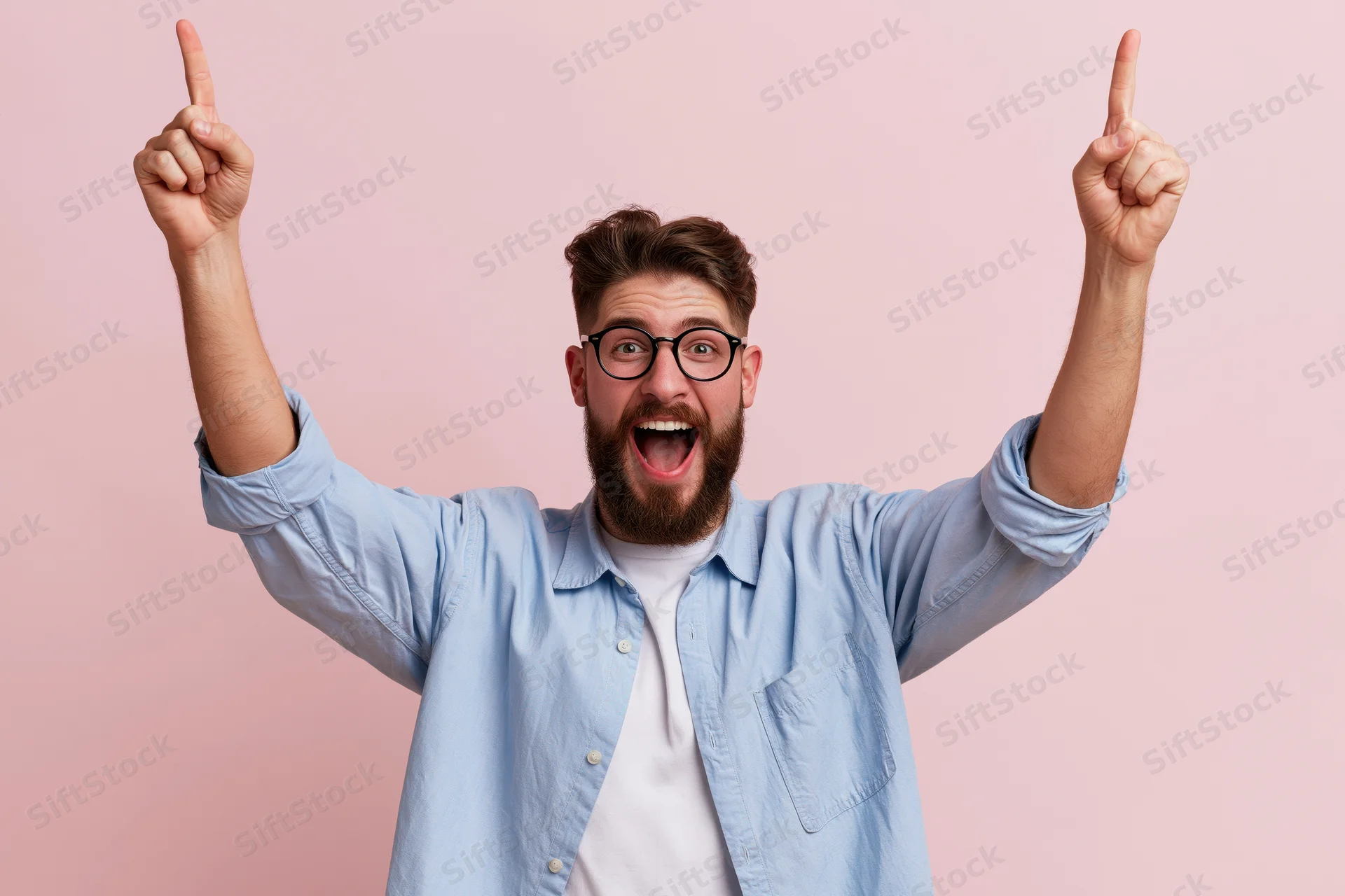 Bearded man celebrating with arms raised pointing upward against pink background