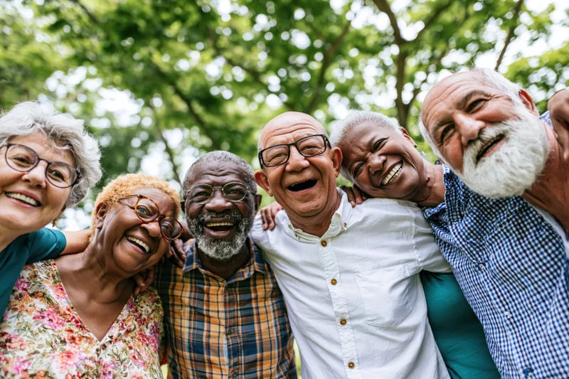 Diverse senior friends smiling together outdoors in a park