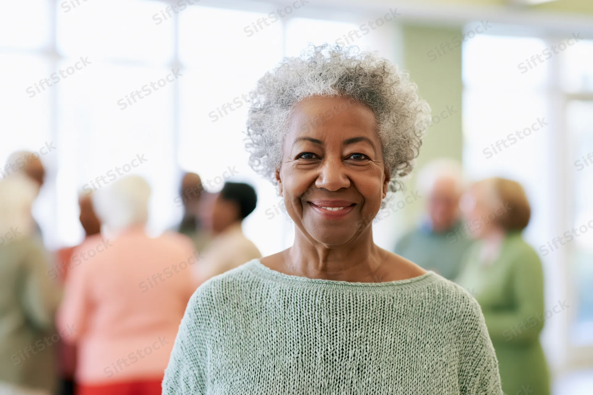 Senior black woman smiling in a knit sweater at a community gathering