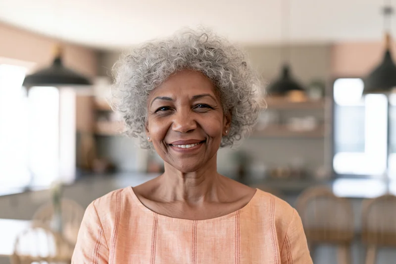 Senior black woman smiling in a kitchen interior with soft natural lighting