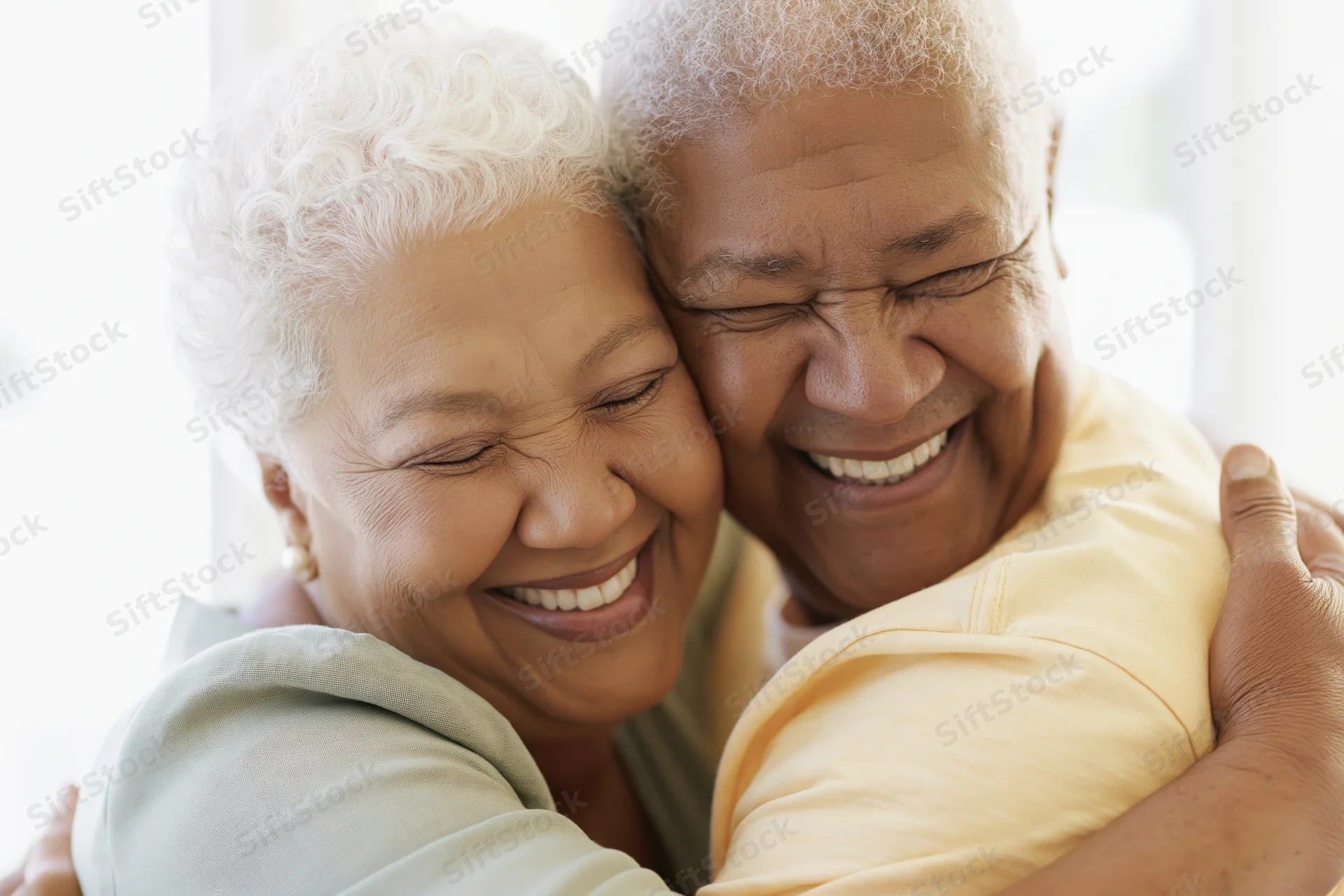Senior african american couple embracing cheek to cheek smiling warmly indoors
