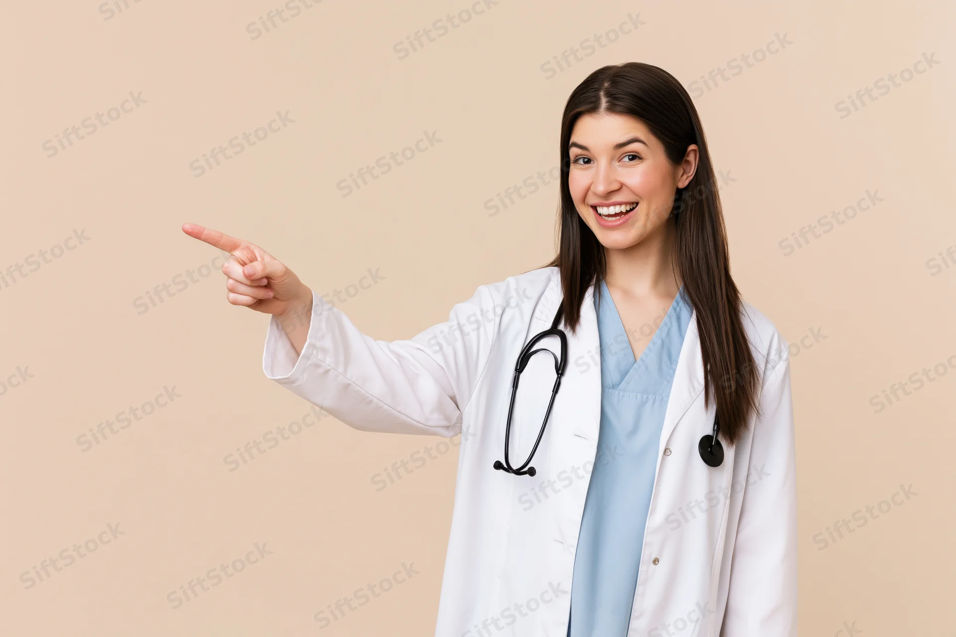Young female doctor in white coat pointing to the left while smiling, beige background