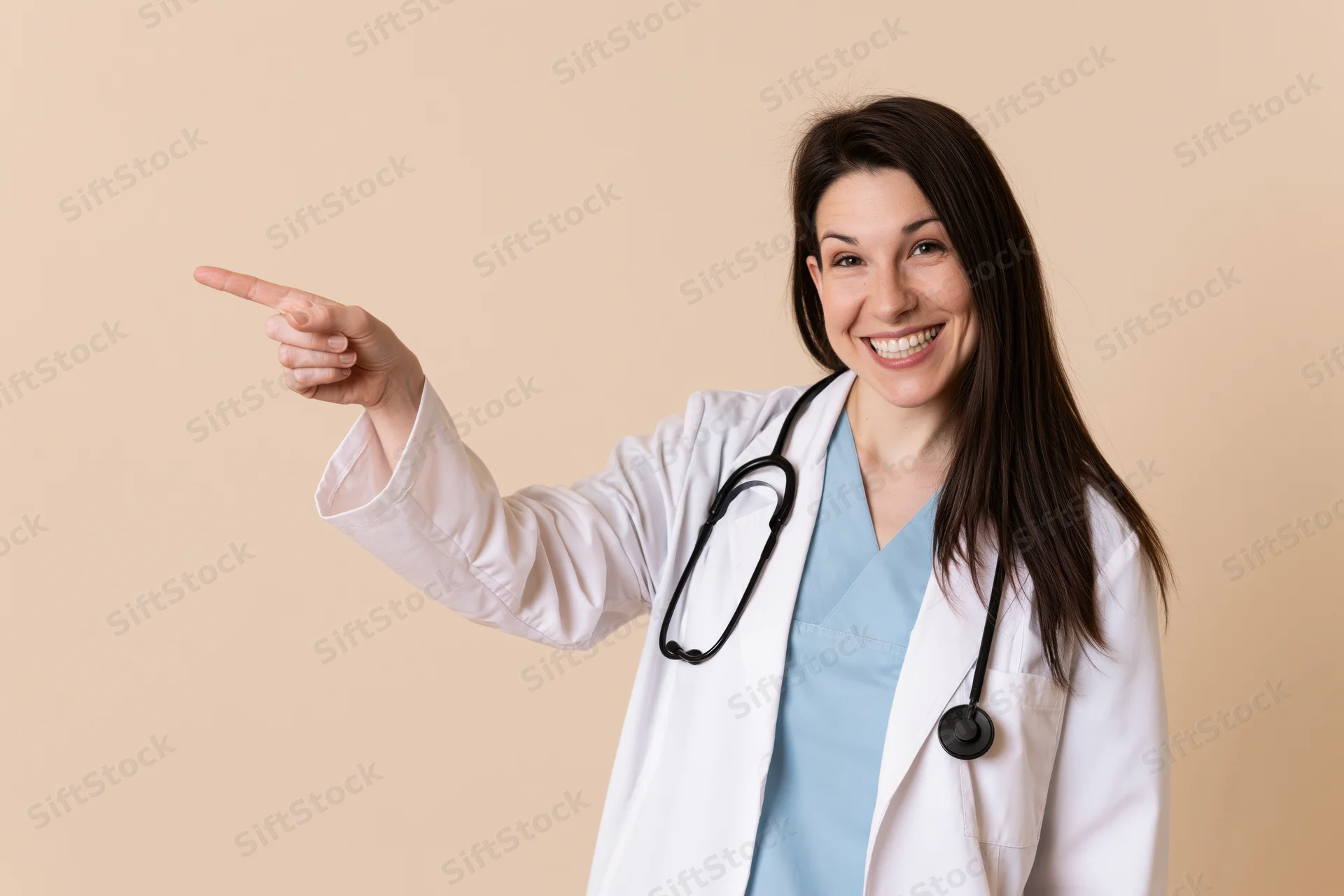 Woman in white lab coat pointing left while smiling in studio setting
