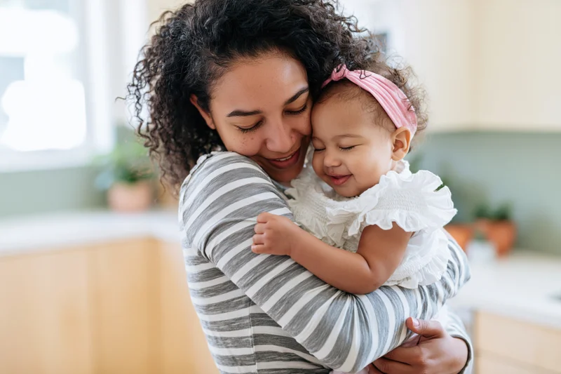 Mother hugging her toddler daughter in a kitchen