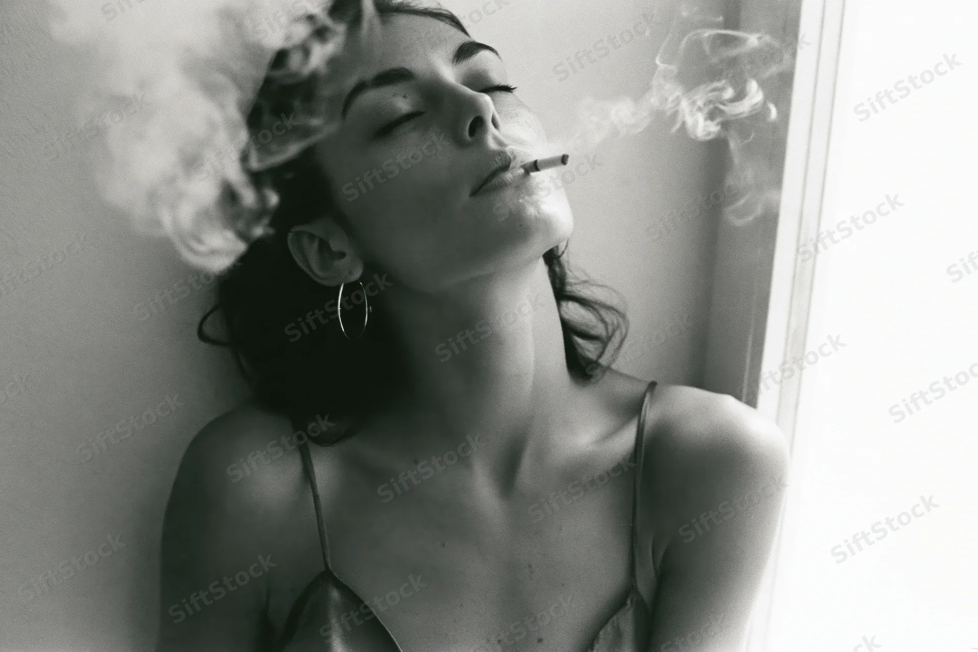 Young woman exhaling cigarette smoke with eyes closed and head tilted back indoors
