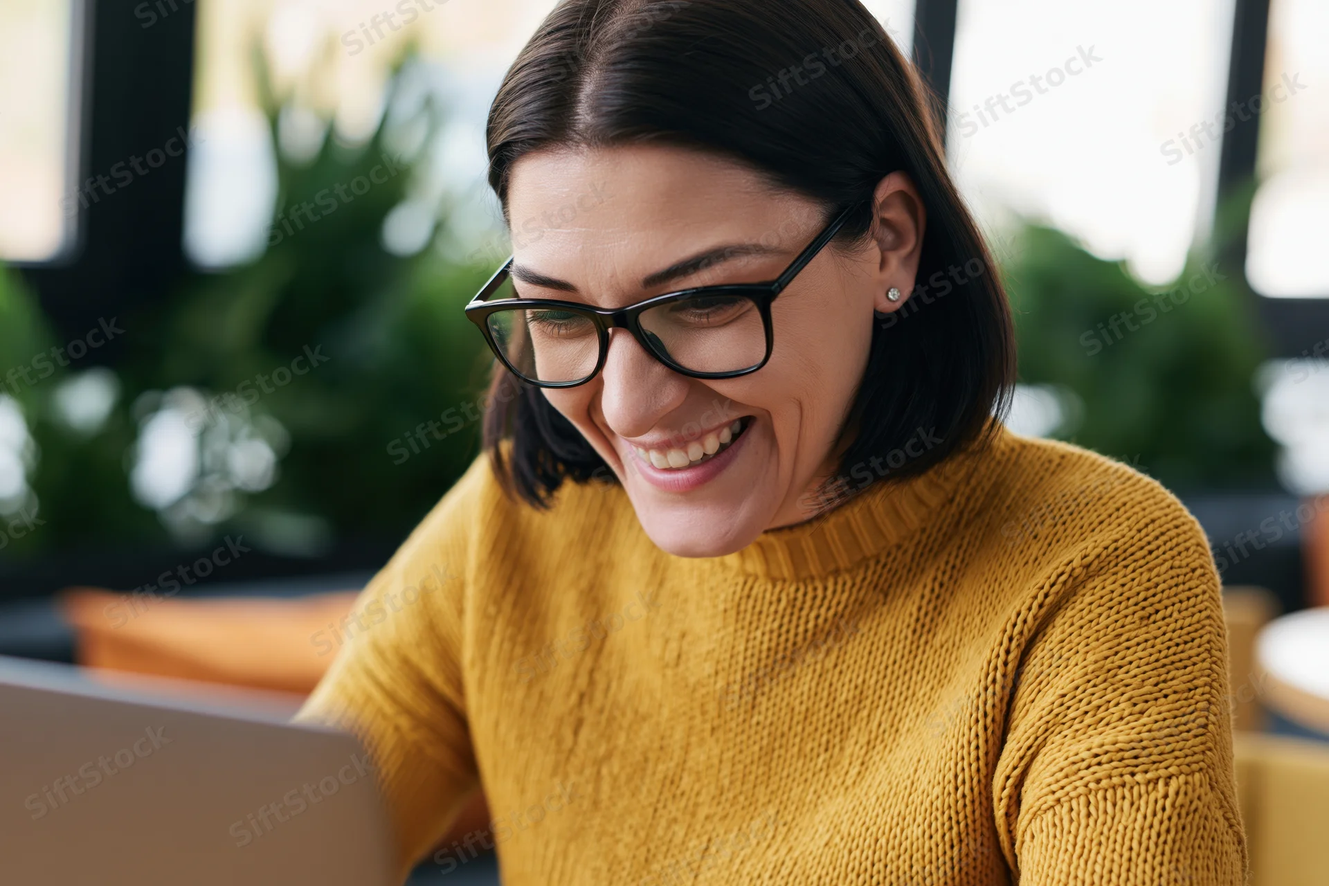 Woman smiling while using laptop in office setting
