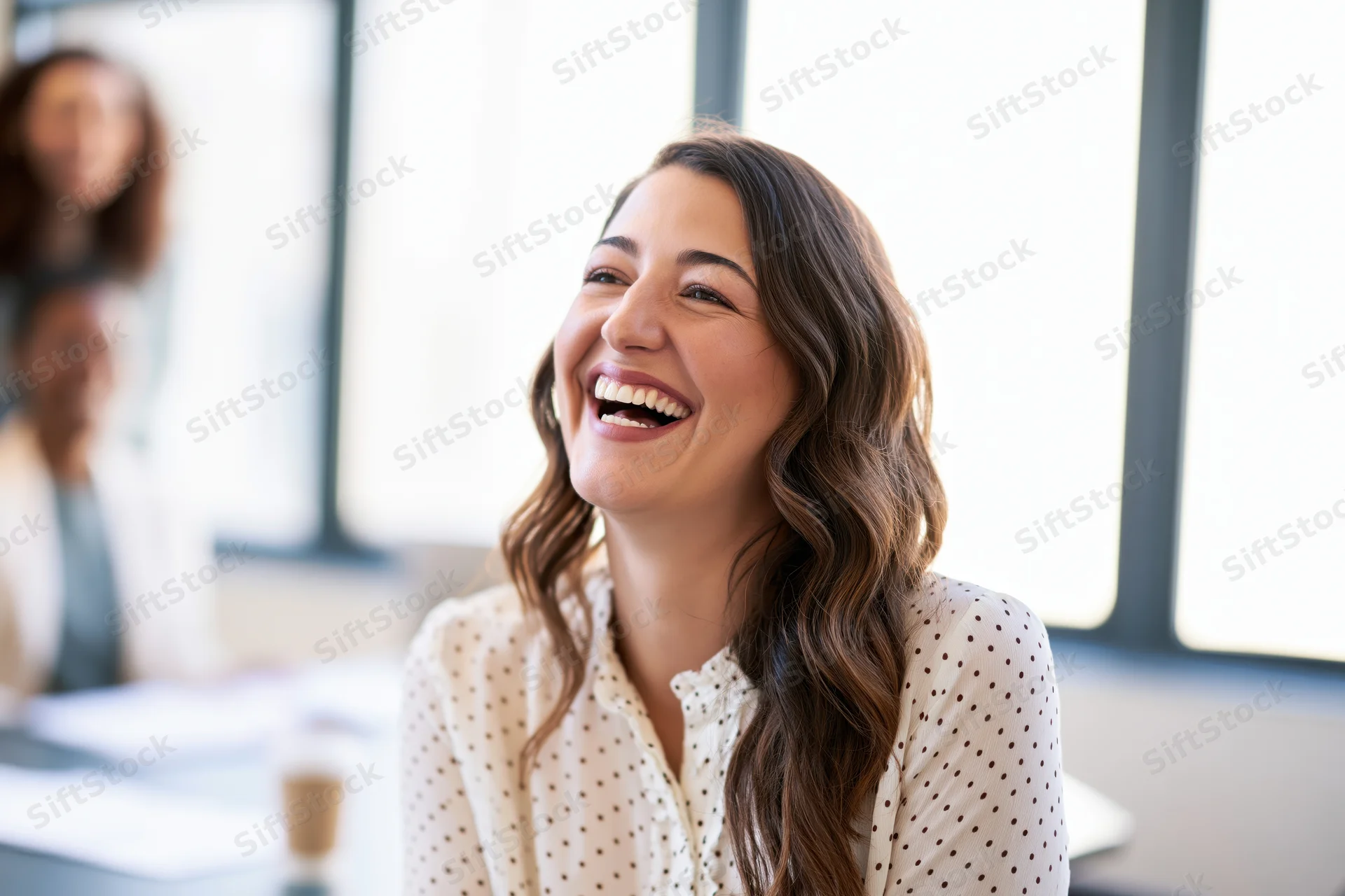 Woman laughing during a meeting in an office setting