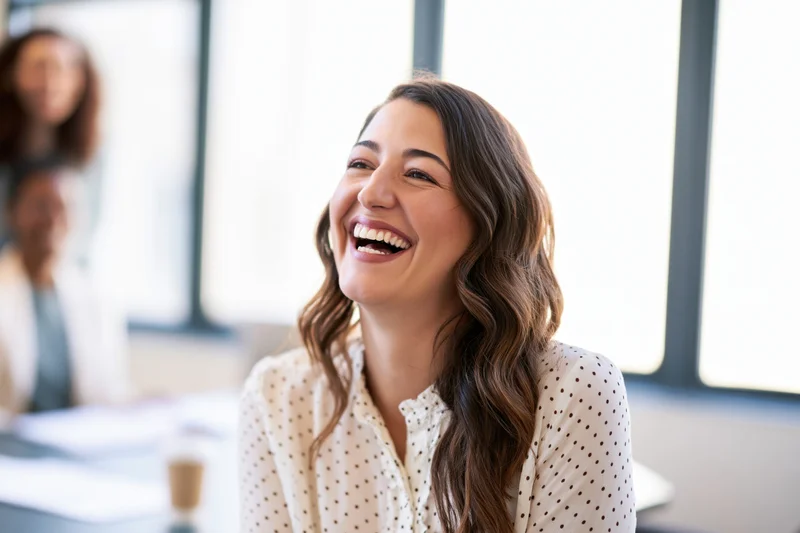 Woman laughing during a meeting in an office setting