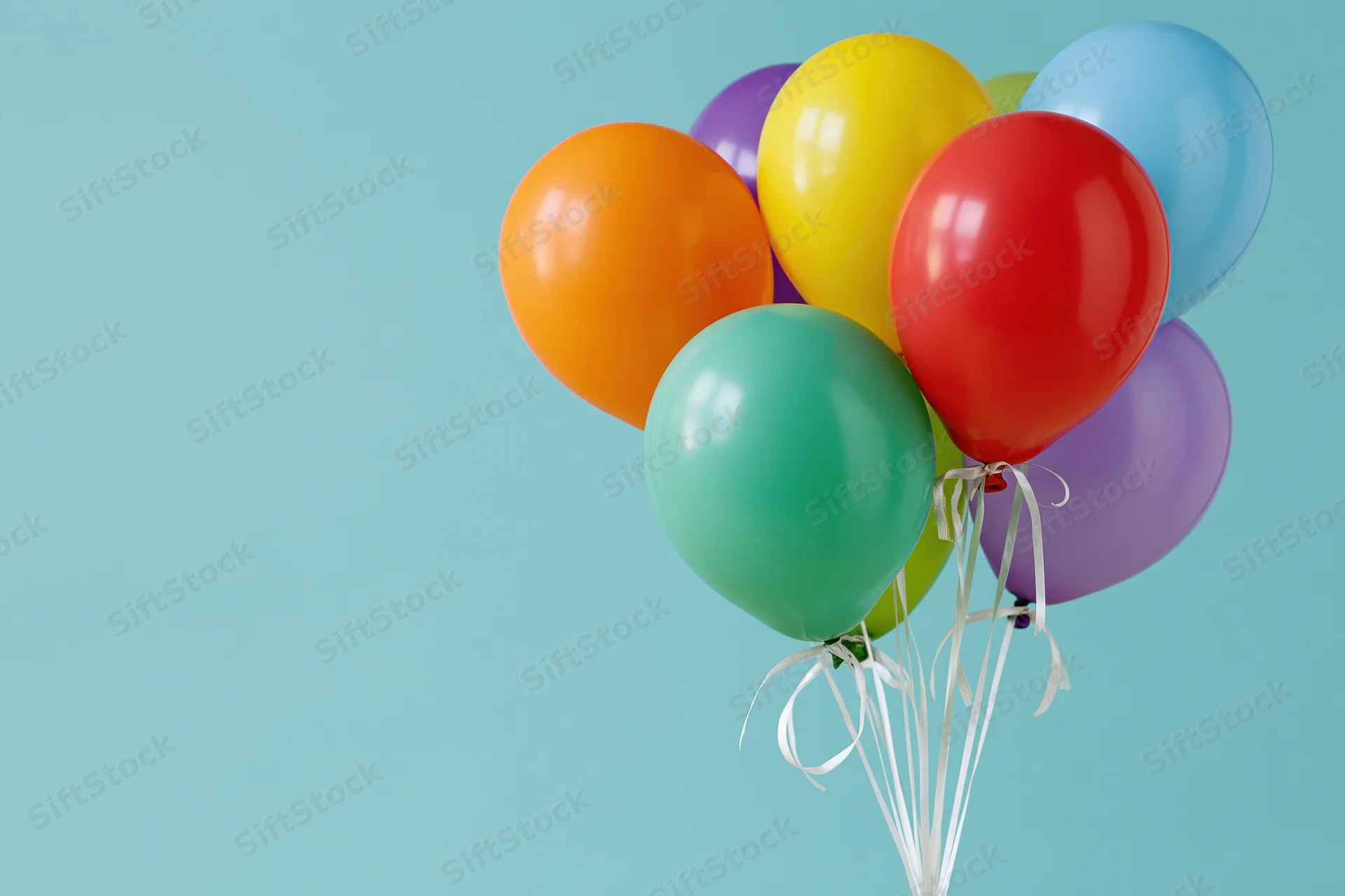 Colorful latex balloons tied together with white ribbons against a light blue background