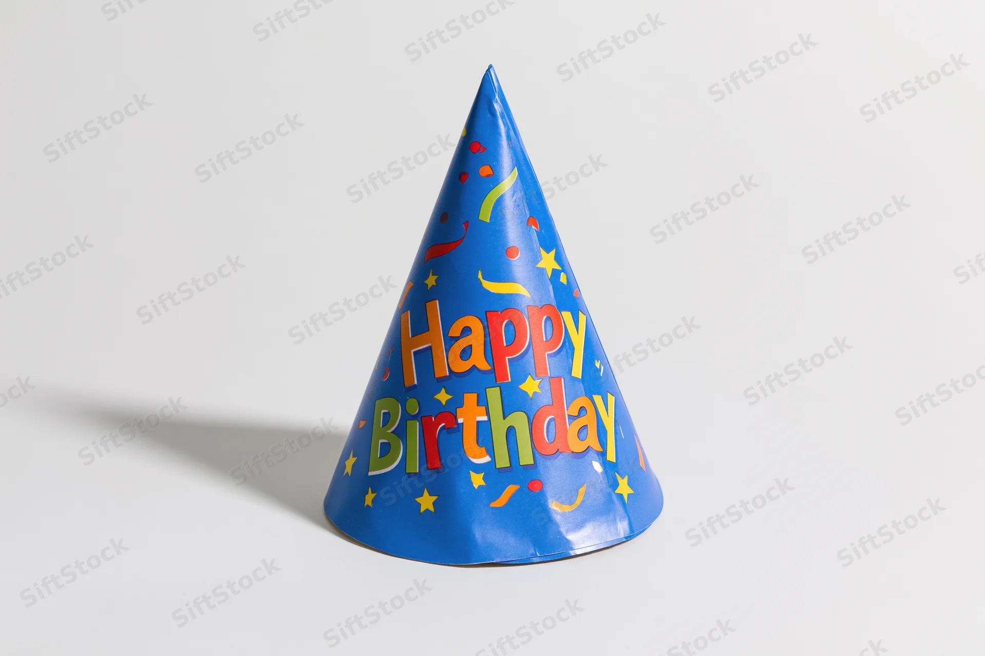 Blue paper birthday party hat standing upright on white surface