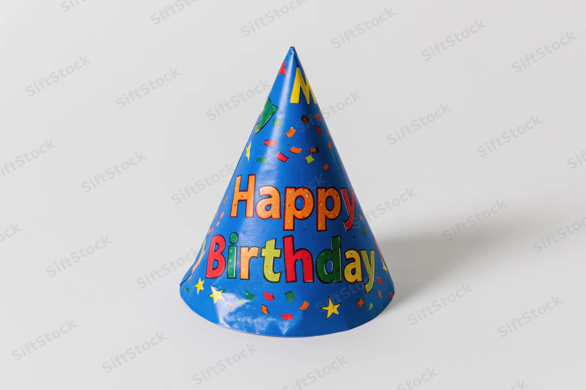 Blue paper party hat with happy birthday text standing upright on white surface