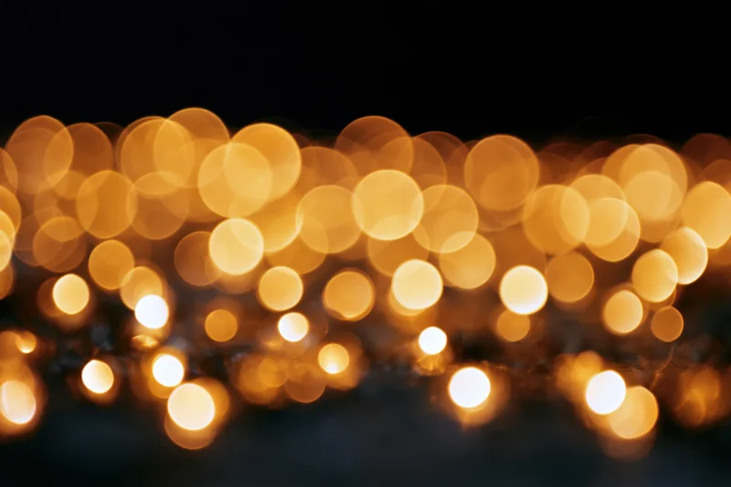Abstract golden bokeh lights glowing softly against dark background