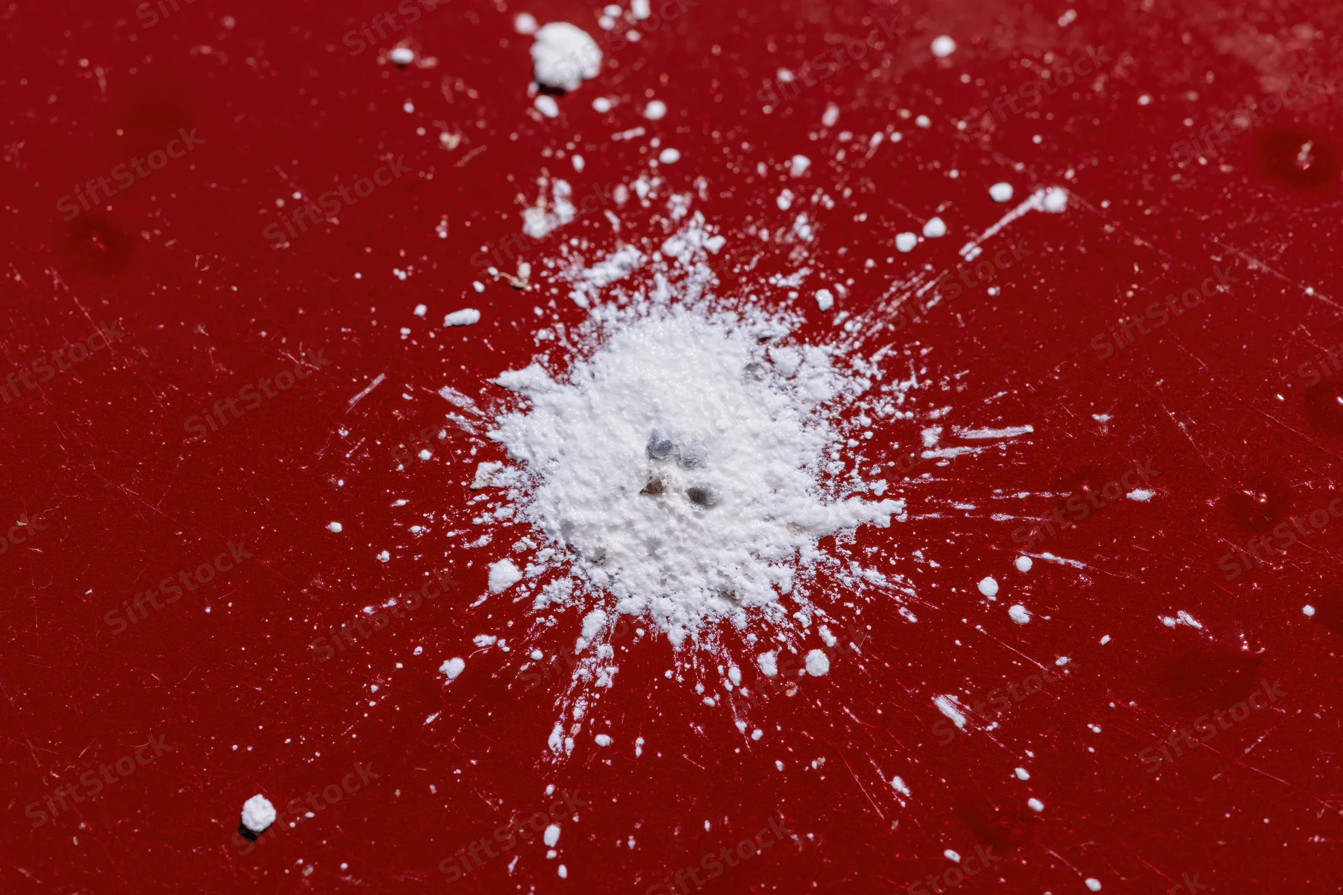 Bird dropping splattered on glossy red car surface
