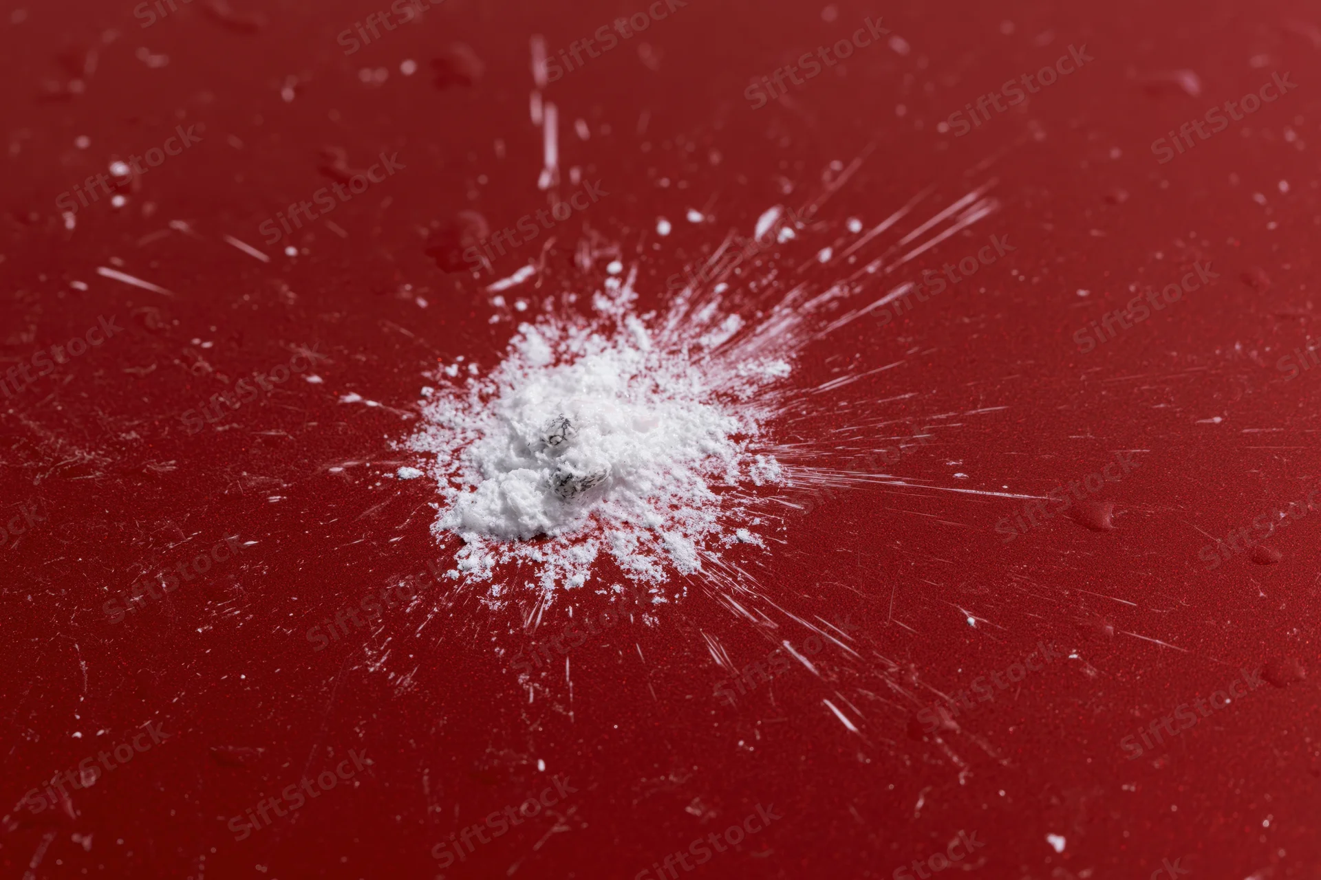 Bird dropping splattered on glossy red car surface