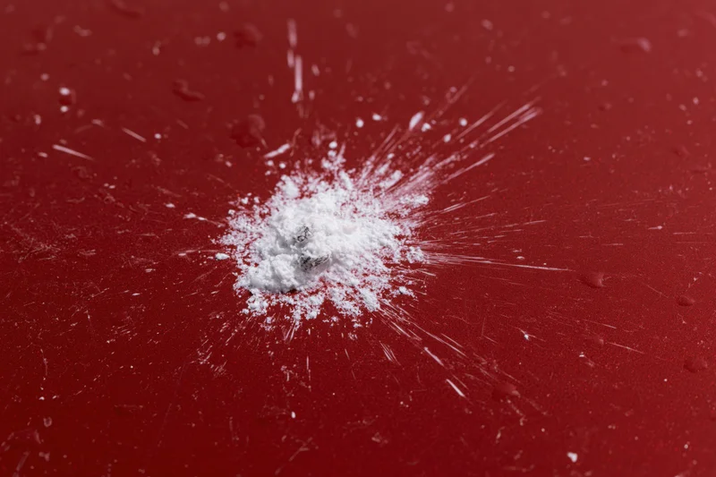 Bird dropping splattered on glossy red car surface