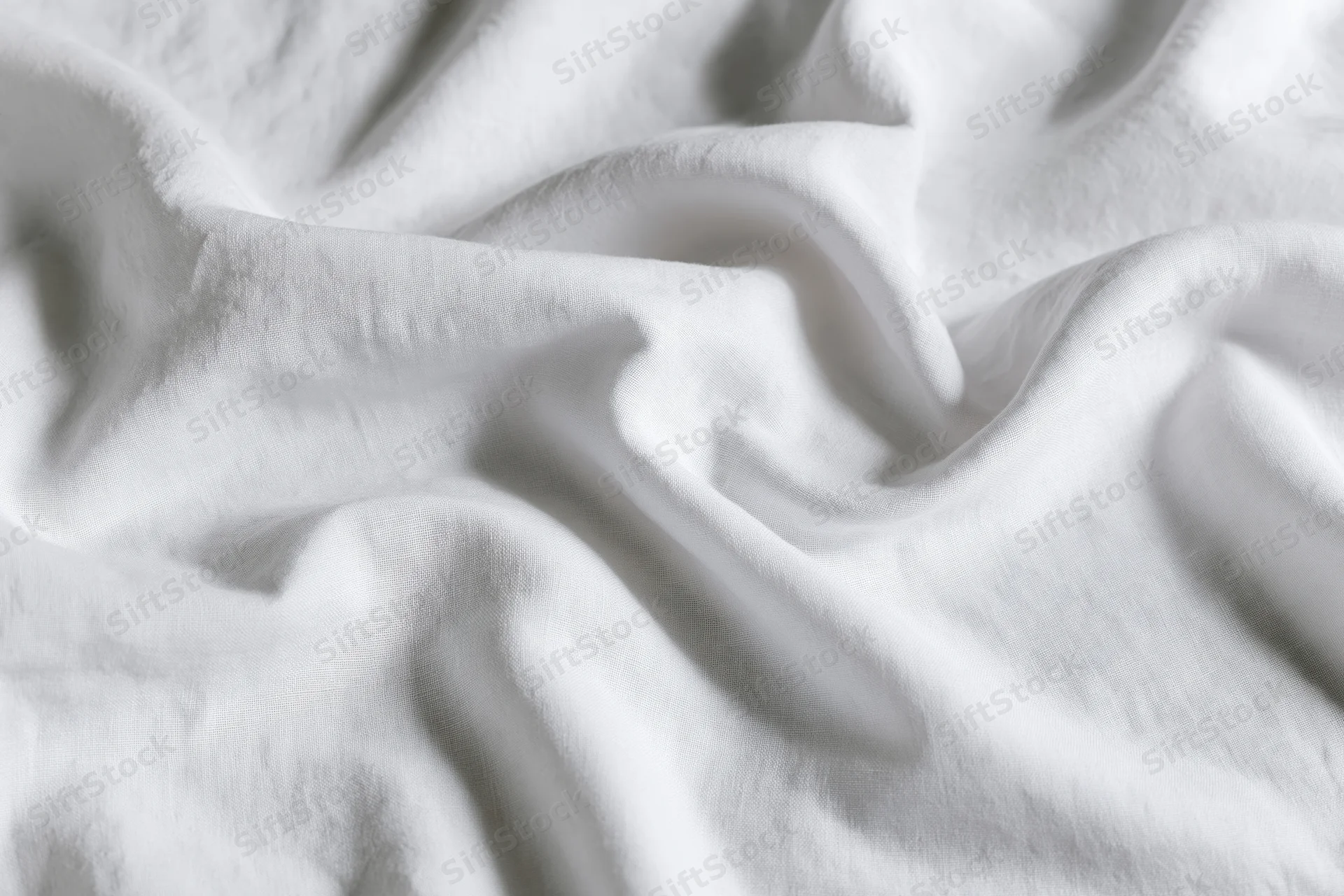 Crumpled white cotton bed sheet in close-up flat lay filling frame