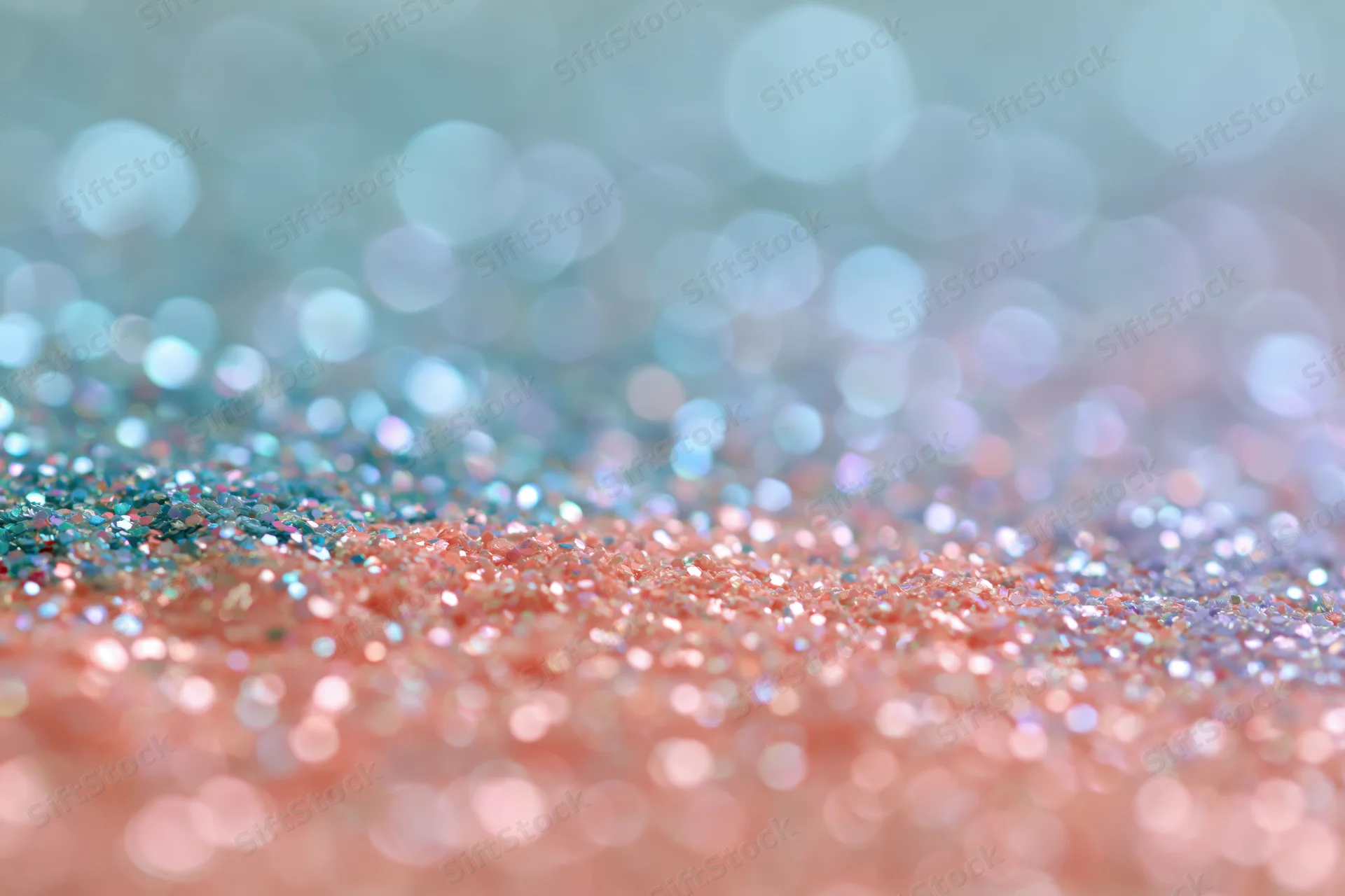 Close-up of rainbow glitter surface with bokeh lights and pastel colors