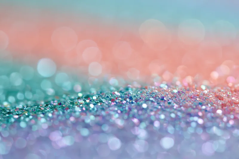 Close-up of rainbow glitter surface with soft bokeh background