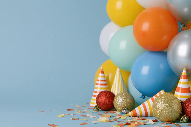 Cluster of colorful party balloons and decorations on blue surface