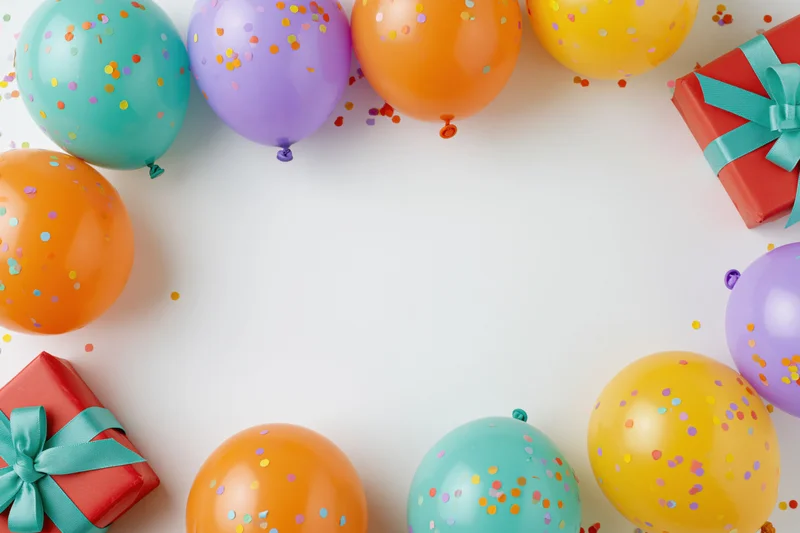 Colorful balloons and gift boxes arranged around white copyspace for birthday party decoration