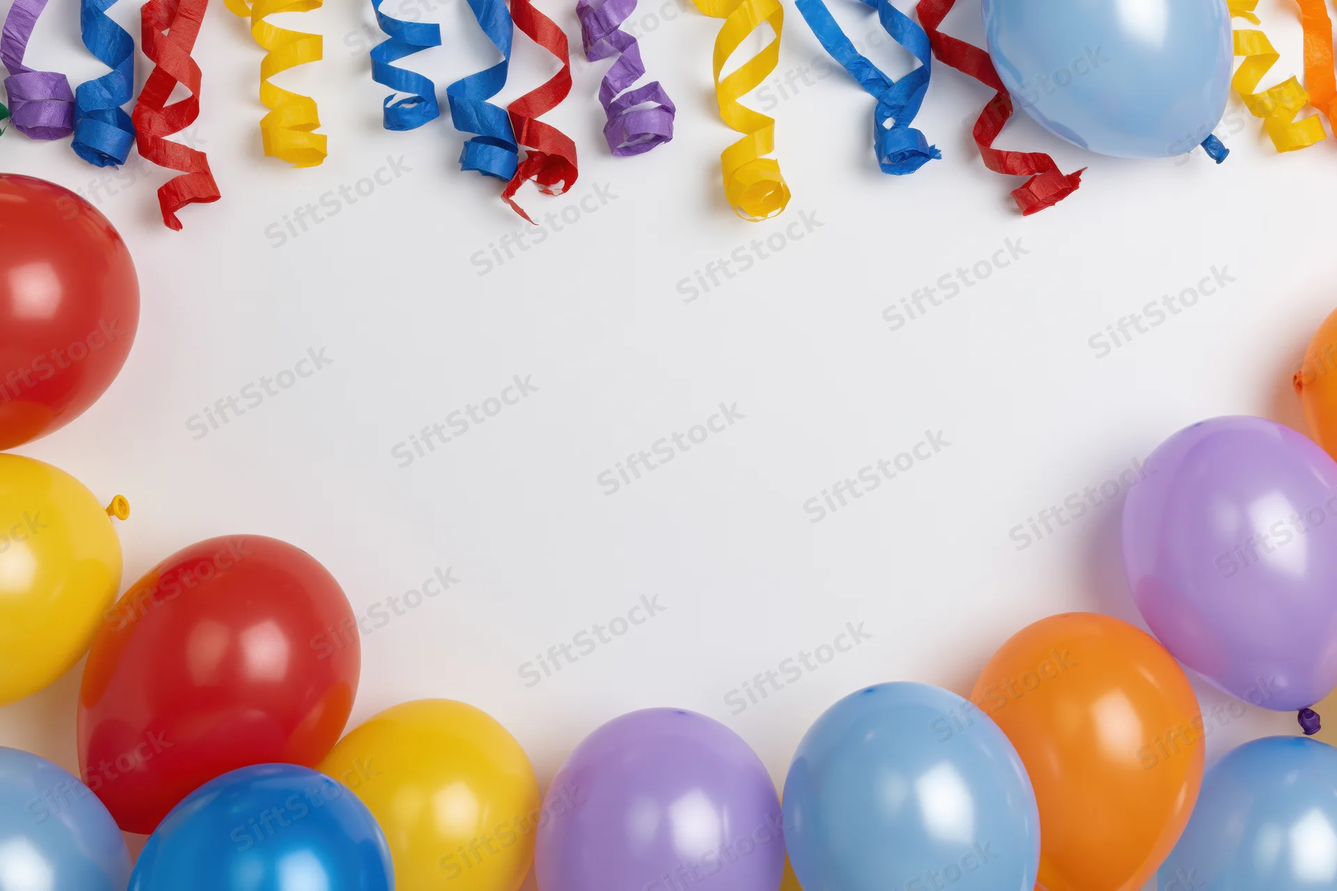 Colorful latex balloons and curled paper streamers arranged along the edges of a white surface, leaving central copyspace