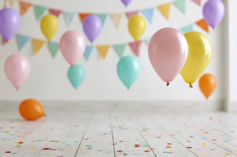 Colorful balloons floating in a decorated room with confetti on the floor