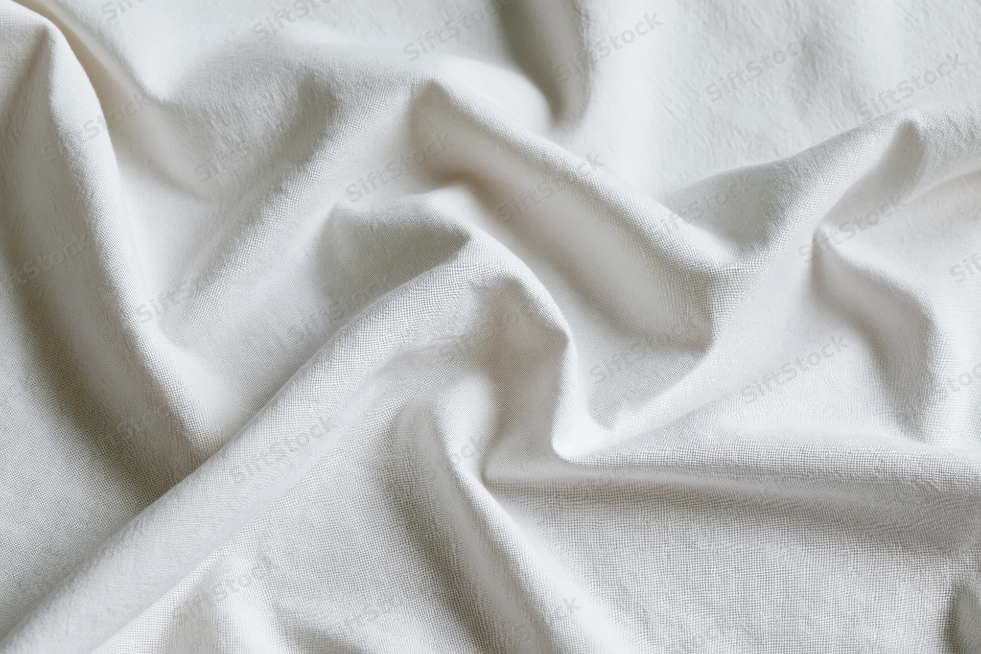 Crumpled white cotton bed sheet filling the frame