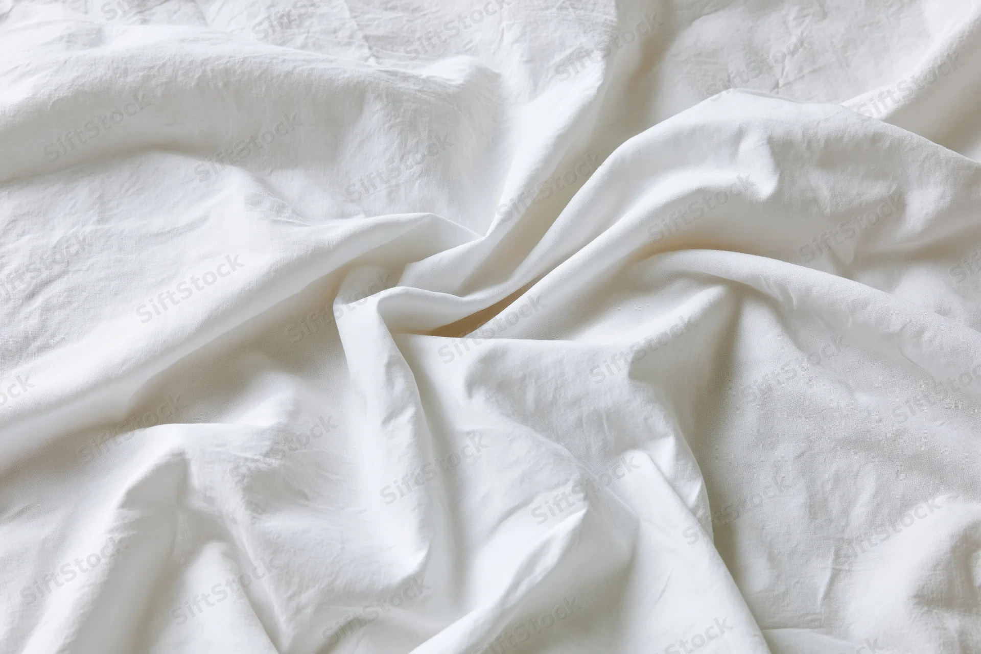 Crumpled white cotton bed sheet filling the frame