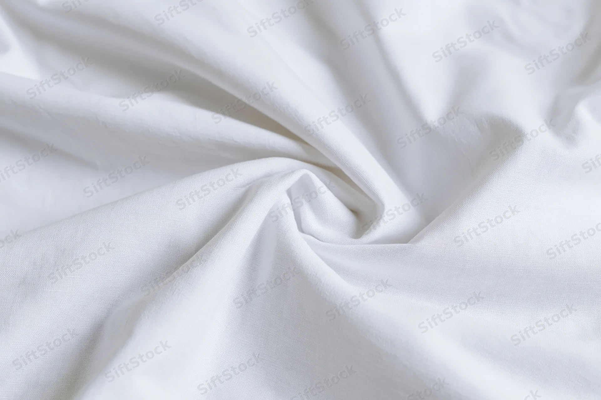 Crumpled white cotton bed sheet filling the frame