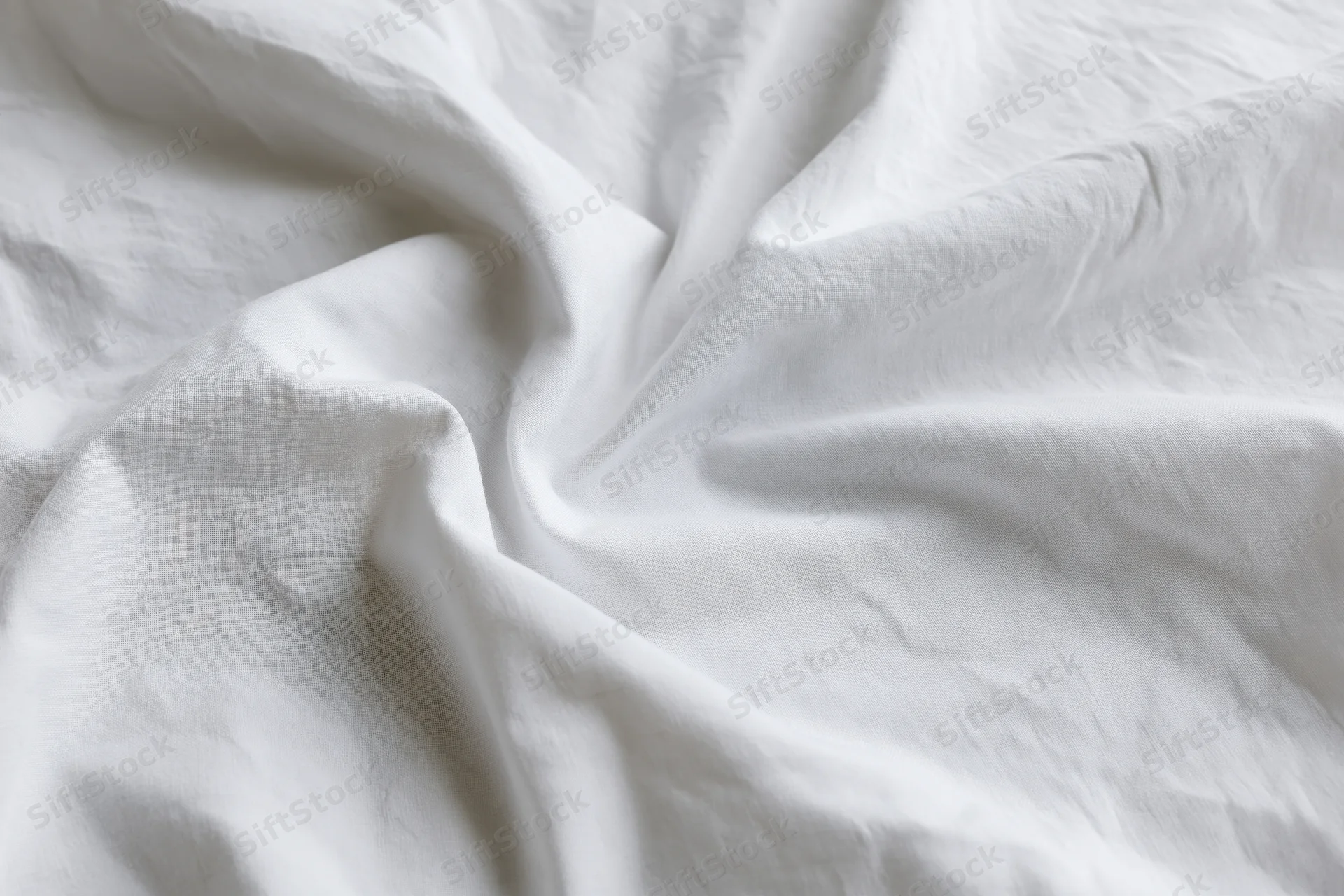 Crumpled white cotton bed sheet filling the frame