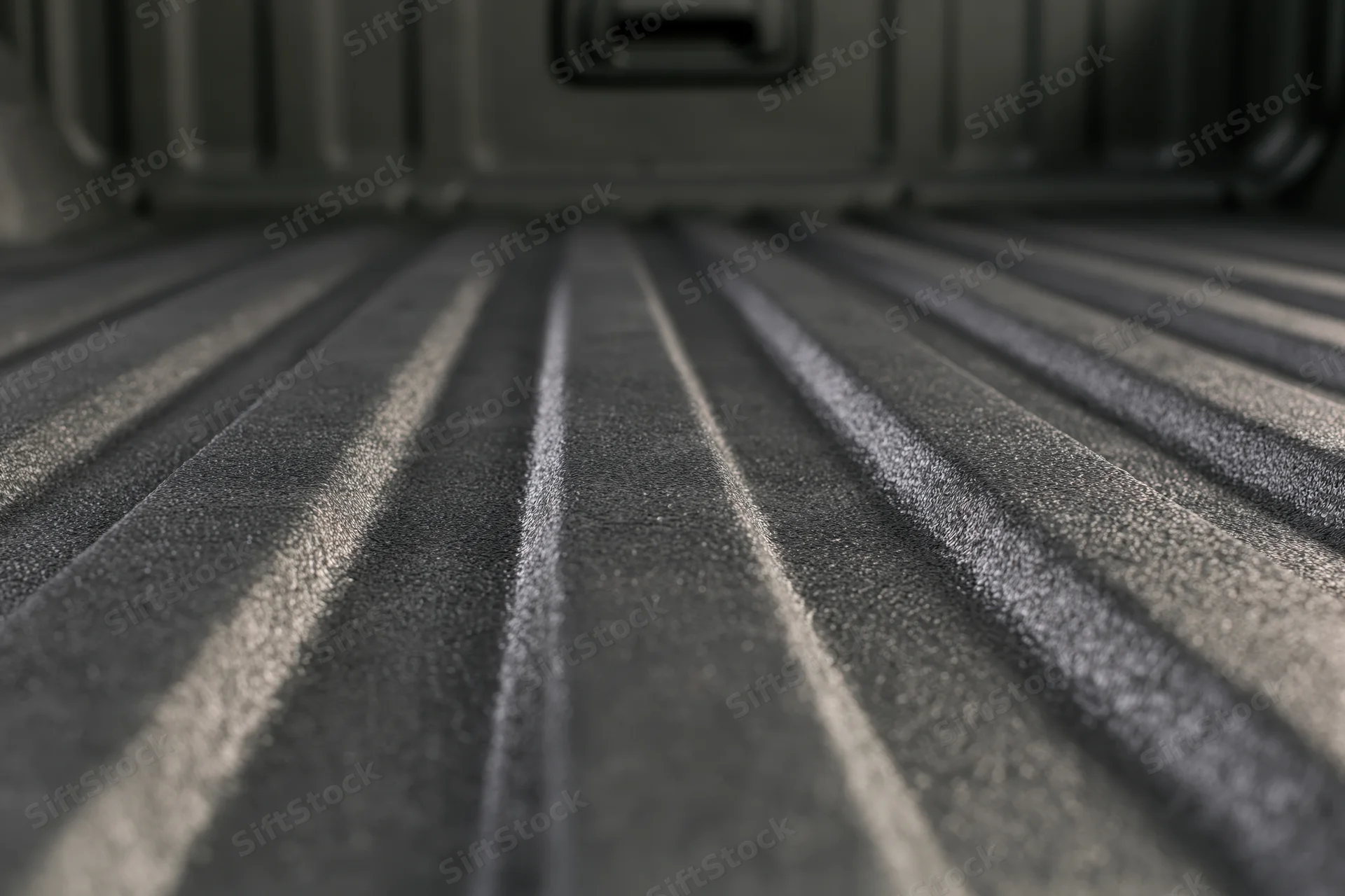 Low-angle view of textured black truck bed liner with ribbed pattern and protective surface