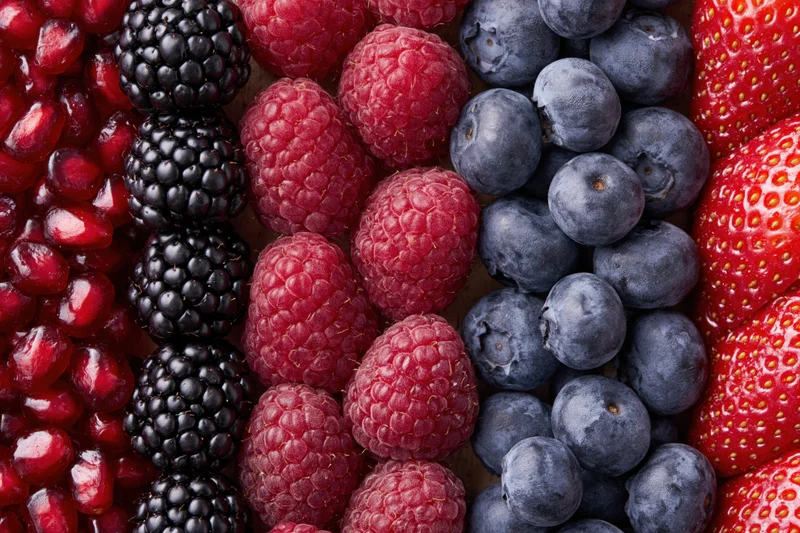 Five varieties of fresh berries arranged in vertical strips