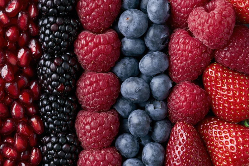 Five varieties of fresh berries arranged in vertical strips