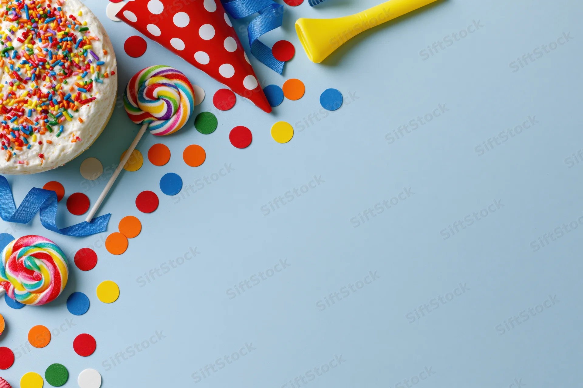 Birthday party items arranged along the left side on a blue background with copyspace