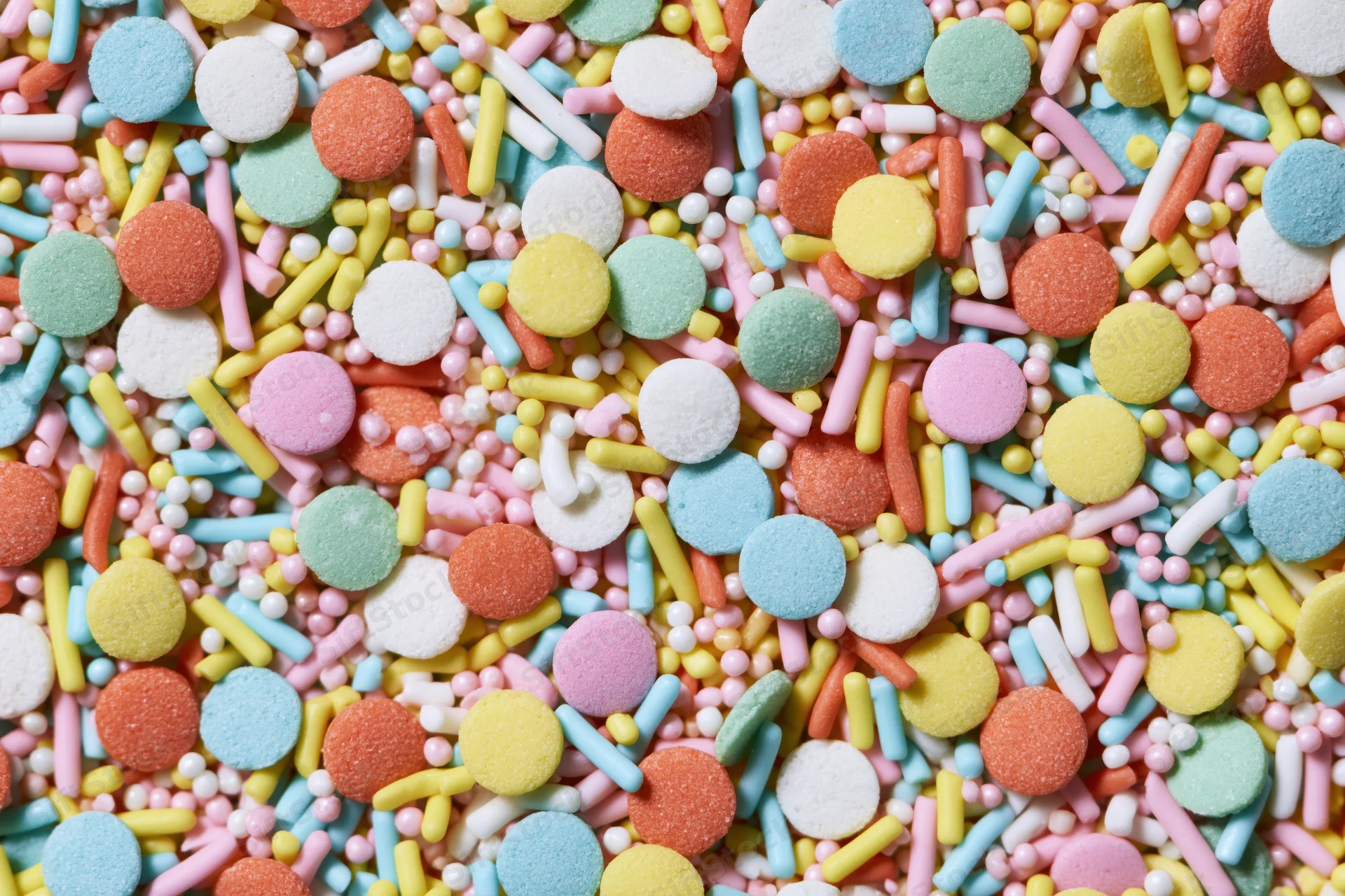 Close-up of colorful candy sprinkles scattered in a flat lay pattern