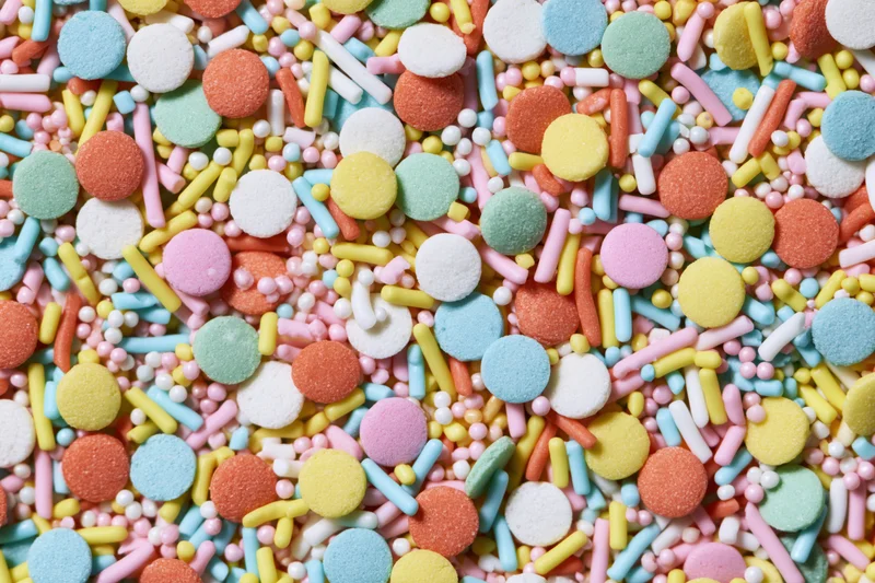Close-up of colorful candy sprinkles scattered in a flat lay pattern
