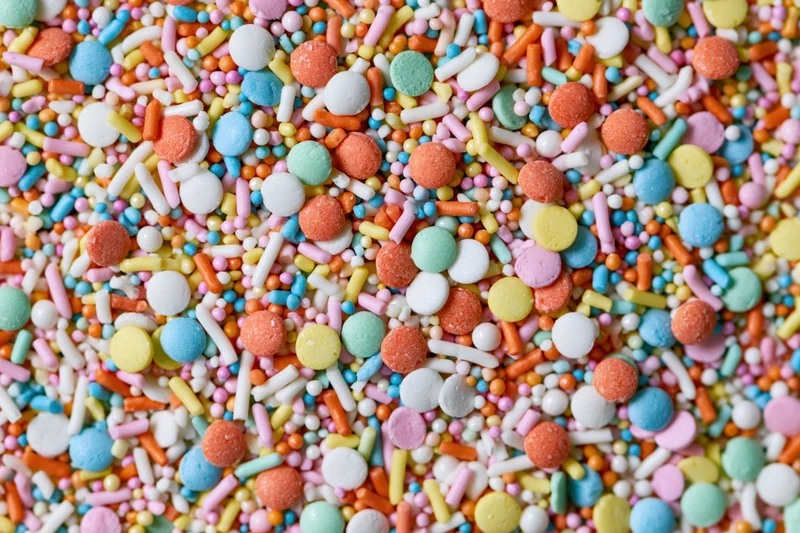 Close-up of colorful candy sprinkles scattered across the frame in a flat lay arrangement