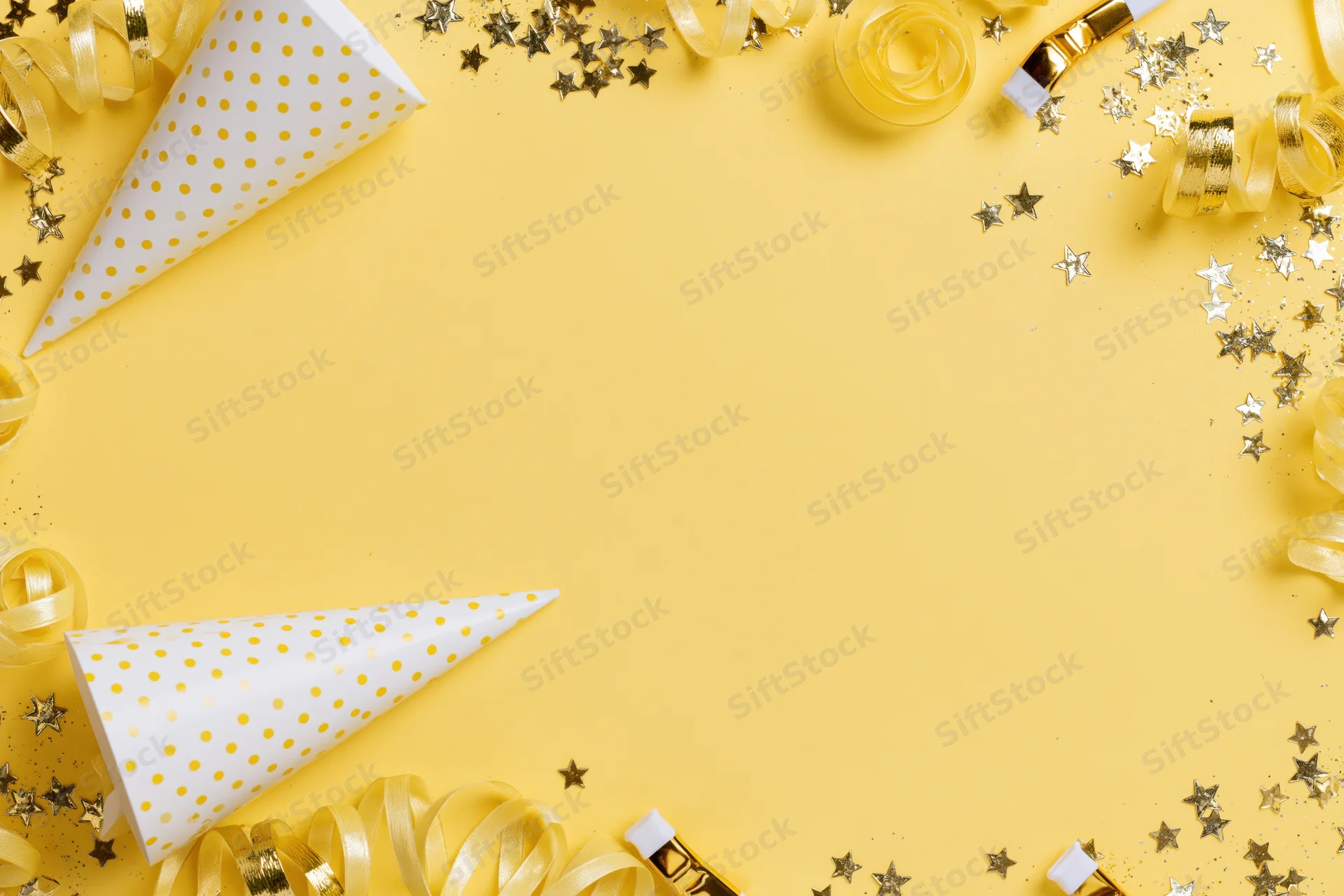 Party supplies arranged around edges of yellow surface with copyspace in center