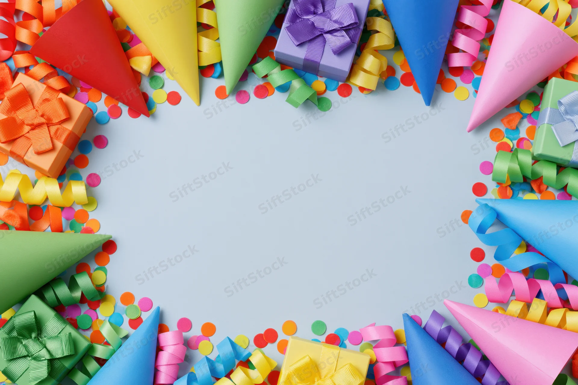 Colorful party supplies arranged in a frame around a light blue copyspace