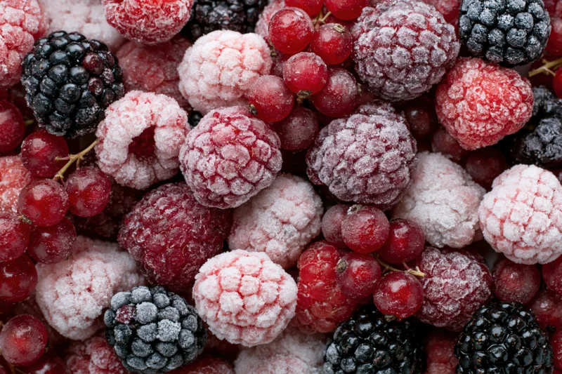 Frozen mixed berries including raspberries blackberries and redcurrants in a closeup pile